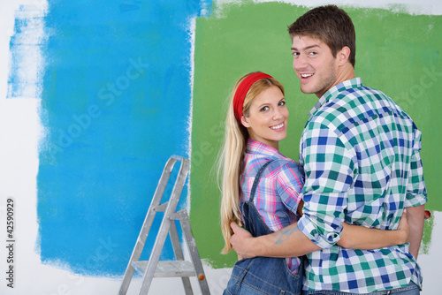 Photo: happy couple paint wall at new home happy couple paint wall at new home