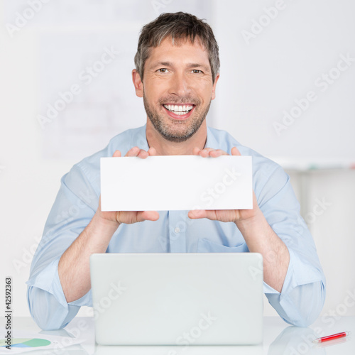 Foto: mann mit laptop und schild mann mit laptop und schild