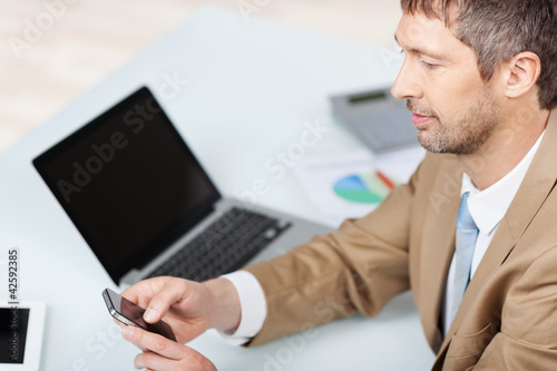 Foto: geschäftsmann mit laptop und handy geschäftsmann mit laptop und handy
