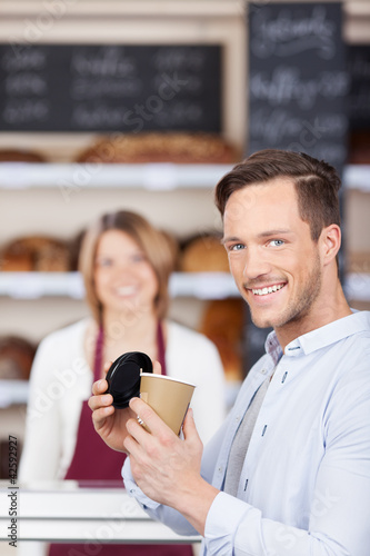 Photo: zufriedener kunde mit kaffee in der bäckerei zufriedener kunde mit kaffee in der bäckerei