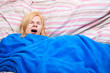 Sleepy woman yawn in a duvet