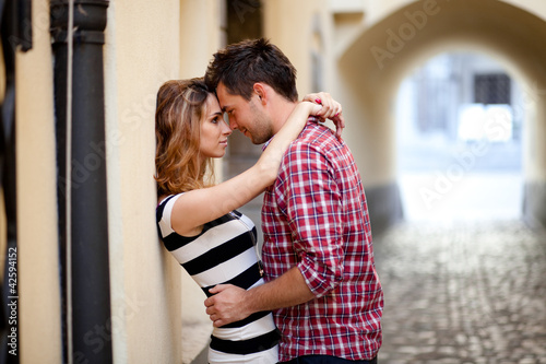 Photo: Young couple in love, hugging in the old part of town Young couple in love, hugging in the old part of town