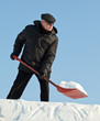 Photo: Man shovelling snow with a red shovel Man shovelling snow with a red shovel