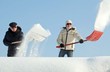 Photo: People shovelling snow on a roof People shovelling snow on a roof