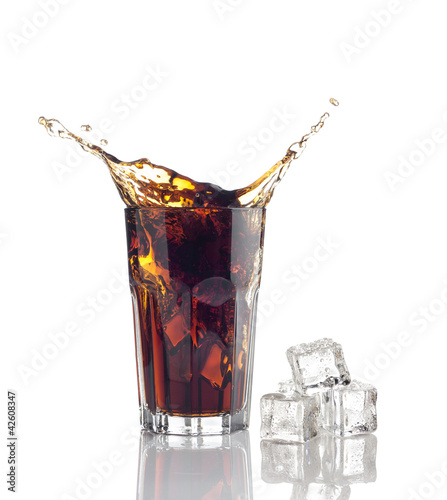 Photo: splash in glass of cola with ice cubes splash in glass of cola with ice cubes