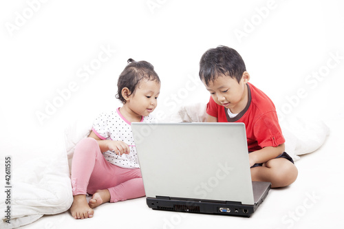 Photo: Asian sibling using laptop Asian sibling using laptop