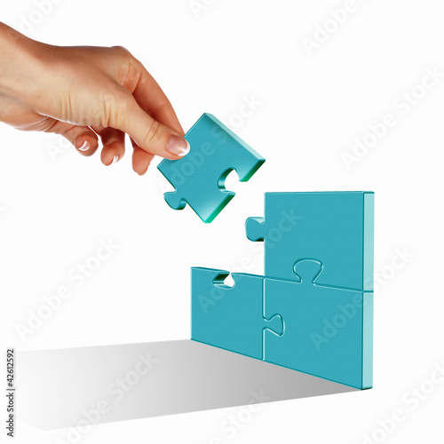 Foto: Puzzle pieces and human hand Puzzle pieces and human hand