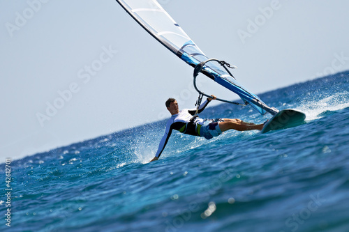 Photo: Young man surfing the wind in splashes of water Young man surfing the wind in splashes of water