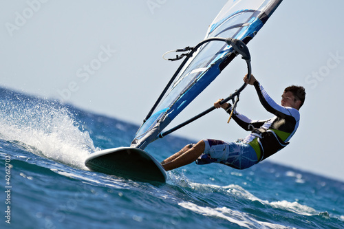 Fototapeta Side view of young windsurfer