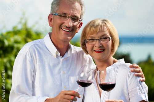 Foto: Glückliches Paar trinkt Wein am See im Sommer Glückliches Paar trinkt Wein am See im Sommer