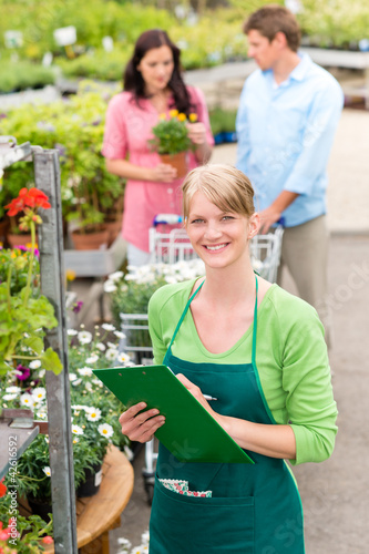 Foto: Smiling florist woman at garden centre inventory Smiling florist woman at garden centre inventory