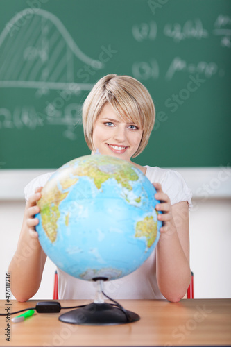 Photo: schülerin mit globus vor der tafel schülerin mit globus vor der tafel