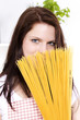 Foto: junge lächelnde frau versteckt sich hinter spaghetti junge lächelnde frau versteckt sich hinter spaghetti