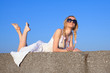 Young woman in white sundress lying on open air