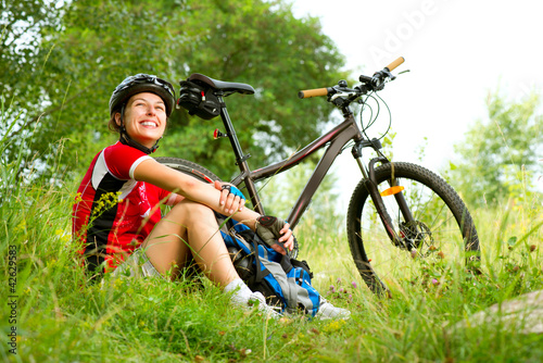 Photo: Happy Young Woman riding bicycle outside. Healthy Lifestyle Happy Young Woman riding bicycle outside. Healthy Lifestyle