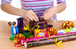 Wrapping presents surrounded by  paper, ribbon and bows