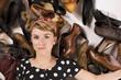 Frau umgeben von vielen Schuhen