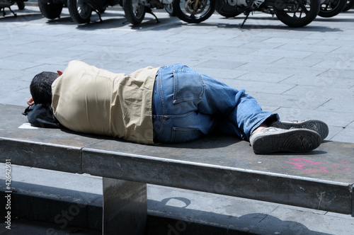 Foto: Uomo sdraiato su panchina Uomo sdraiato su panchina