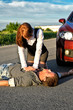 Photo: Young man reanimation on a road. Concept first aid Young man reanimation on a road. Concept first aid