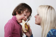 Foto: Mom giving a banana to his daughter Mom giving a banana to his daughter