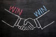 Foto: Mutual benefit concept of handshaking on blackboard Mutual benefit concept of handshaking on blackboard