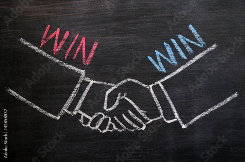 Photo: Mutual benefit concept of handshaking on blackboard Mutual benefit concept of handshaking on blackboard