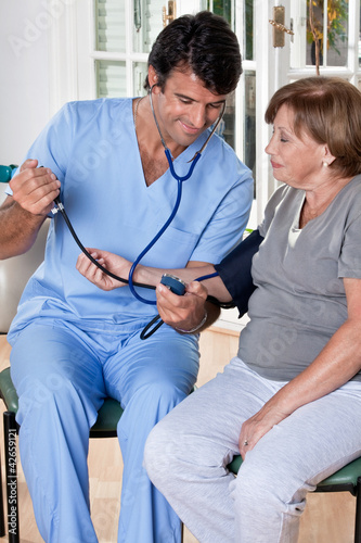 Photo: Doctor taking the Blood Pressure Doctor taking the Blood Pressure