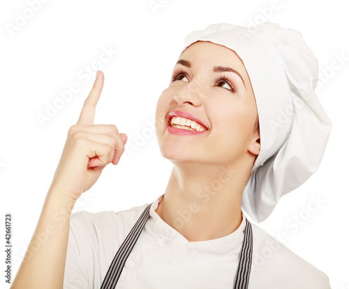 Photo: Chef woman in white uniform and hat pointing up Chef woman in white uniform and hat pointing up