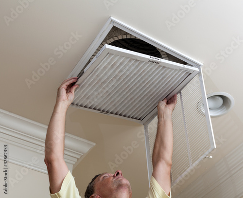 Photo: Senior man opening air conditioning filter in ceiling Senior man opening air conditioning filter in ceiling