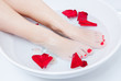 woman spa pedicure foot treatment with water and flower