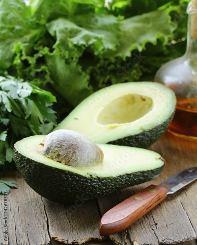 Photo: avocado cut in half on a wooden table avocado cut in half on a wooden table