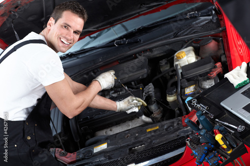 Photo: Auto mechanic checking oil. Auto mechanic checking oil.