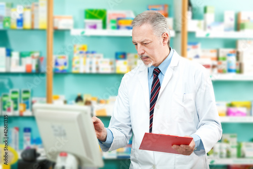 Photo: Pharmacist looking at the computer Pharmacist looking at the computer