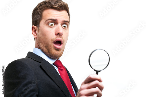 Foto: surprised business man looking through loupe surprised business man looking through loupe