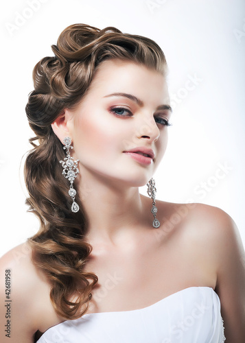 Photo: Beautiful bride in white dress. Festive coiffure and makeup Beautiful bride in white dress. Festive coiffure and makeup