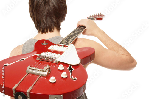 Photo: A young boy standing with his back with bass guitar A young boy standing with his back with bass guitar