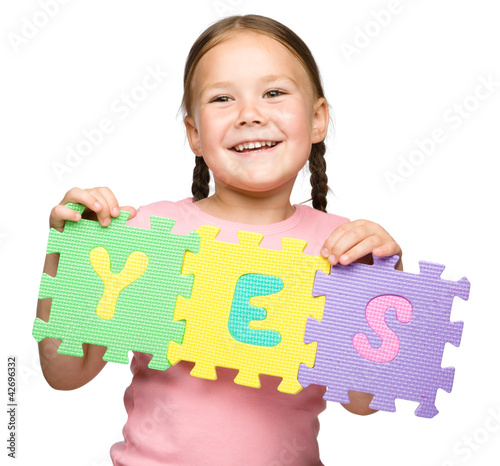Foto: Cute little girl is holding Yes slogan Cute little girl is holding Yes slogan