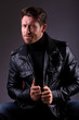 Photo: handsome man in leather jacket seated handsome man in leather jacket seated