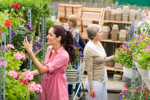 Foto: Woman taking potted plant at garden center Woman taking potted plant at garden center