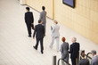 Business people stepping off escalator