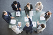 Business people shaking hands across conference room table