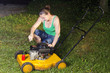 Smiling sexy girl oiling and repairing yellow lawn mover