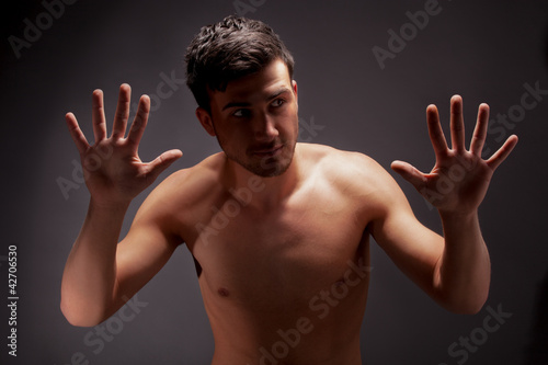 Photo: young muscular man with a bare chested on black. young muscular man with a bare chested on black.