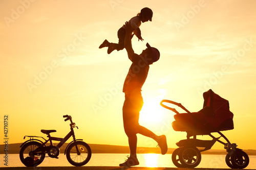 Photo: happy father with child on sunset happy father with child on sunset