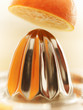 Close up of orange above juicer