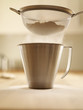 Flour being sifted into measuring cup
