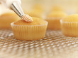 Close up of cupcakes being frosted