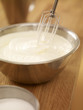 Wire whisk in bowl of cream