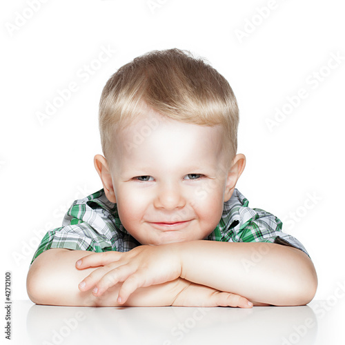 Photo: Portrait of a cute little boy smiling while sitting at table, is Portrait of a cute little boy smiling while sitting at table, is