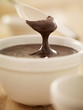 Spoon scooping melted chocolate from bowl